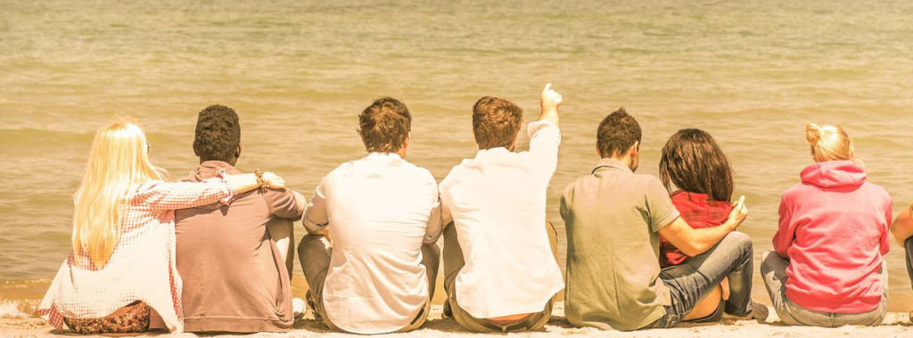 Group Of International Multiracial Friends Sitting At The Beach